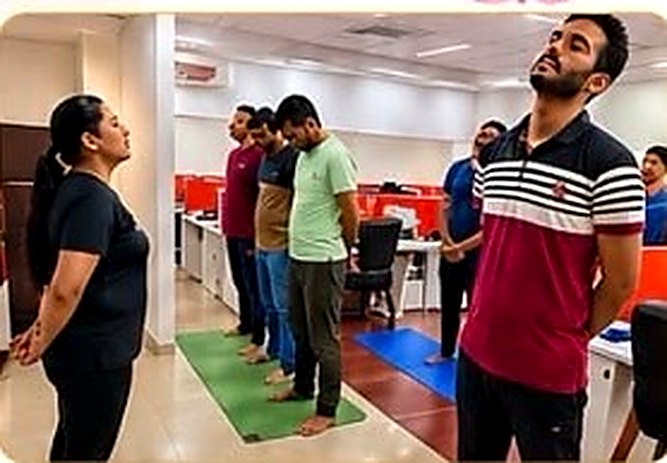 Corporate wellness session at an office in Mumbai — employees doing guided stretching and breathing